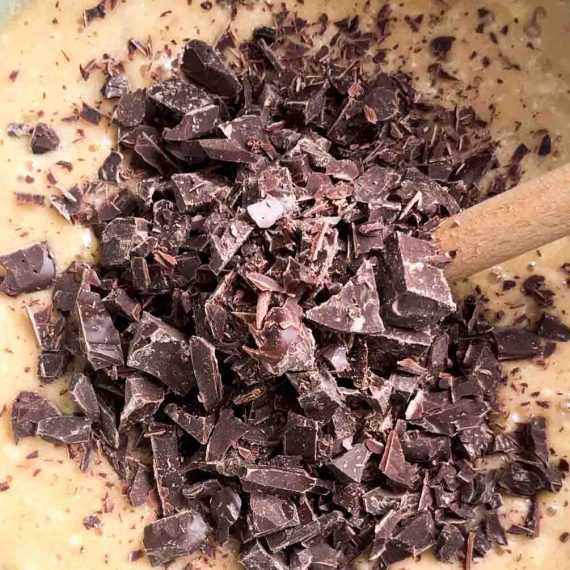 Chocolate chips being added to banana cake batter
