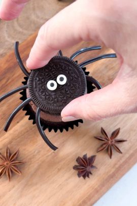 Adding candy legs and eyes to spider cupcakes