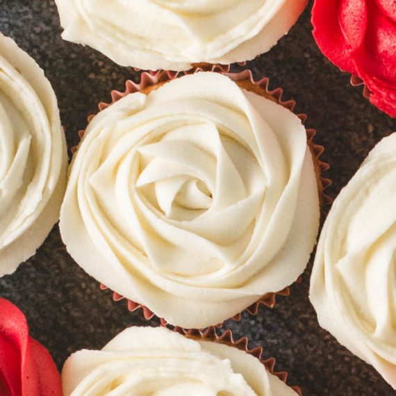 Cupcakes topped with vanilla buttercream and small flag picks