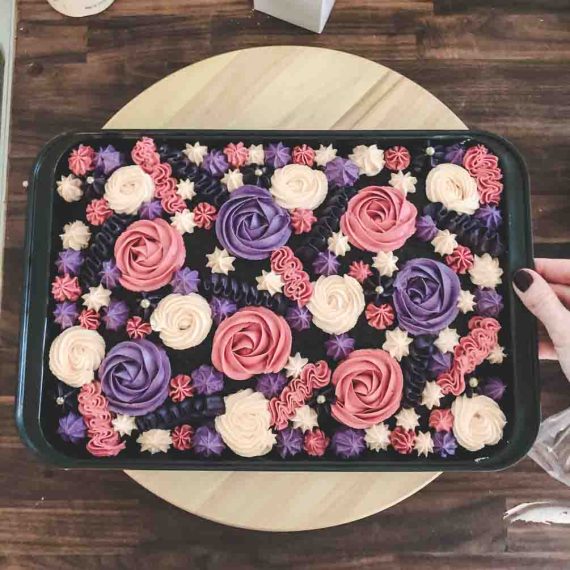 Colorful buttercream frosting spread on chocolate sheet cake