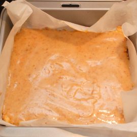 Caramel layer being poured over shortbread base