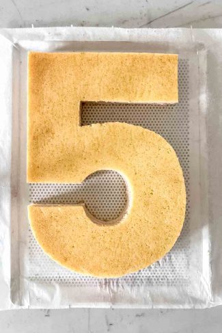 Slicing into a finished raspberry number cake