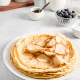 Folded French crêpes stacked on a plate