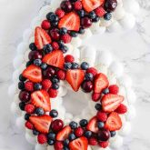 Pavlova number cake layered with fresh summer berries