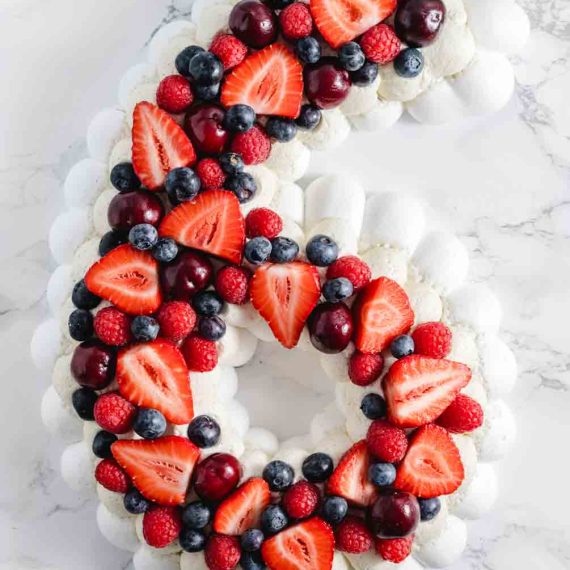 Pavlova number cake layered with fresh summer berries