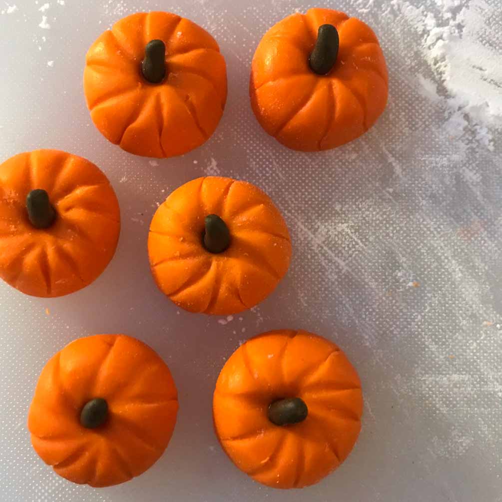 Orange fondant shaped like a pumpkin on the cake