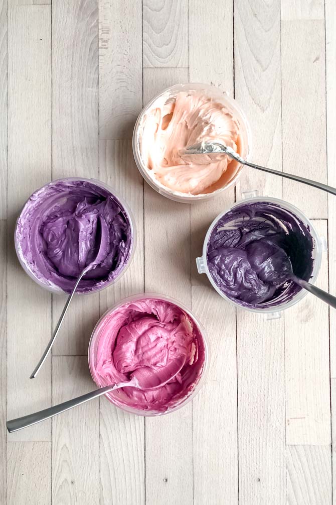 Bowls of vanilla buttercream tinted in different colors