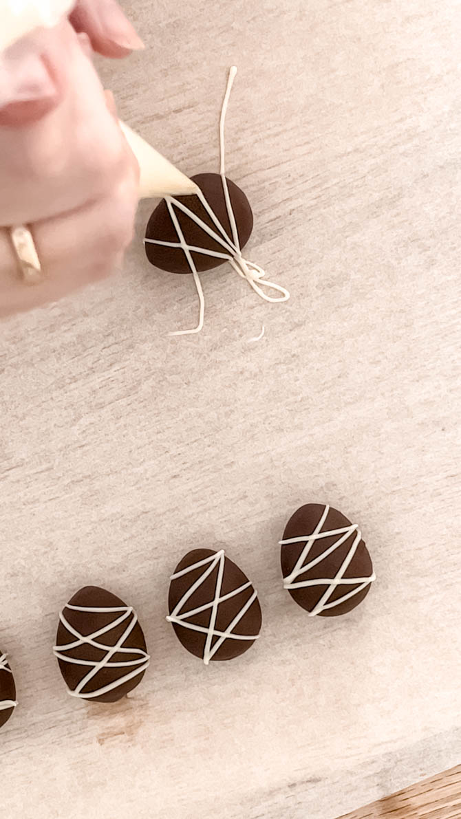 Piping chocolate onto marzipan Easter eggs